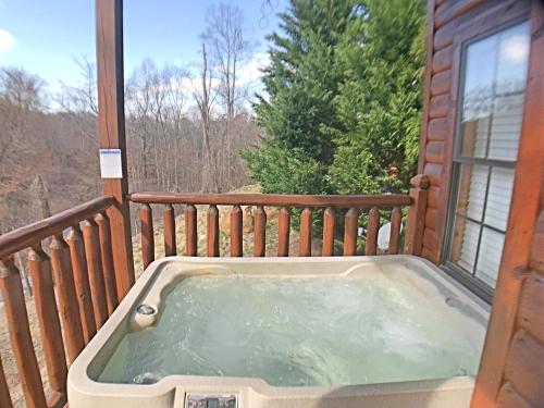 a hot tub on the balcony of a house at Paw Prints Mountain View Cabin in Sevierville