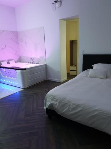 a bedroom with a white bed and a bath tub at Suite Miro Charme et volupté in Perpignan