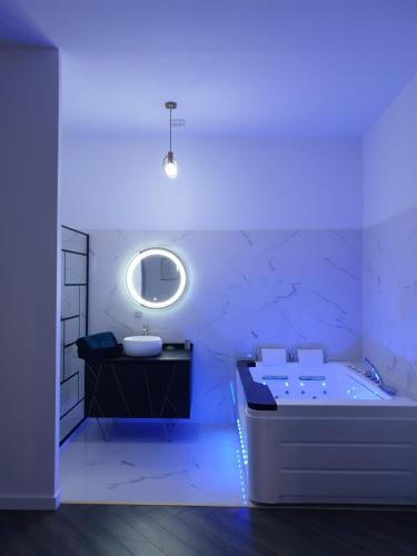 La salle de bains est pourvue d'une baignoire, d'un lavabo et d'un miroir. dans l'établissement Suite Miro Charme et volupté, à Perpignan