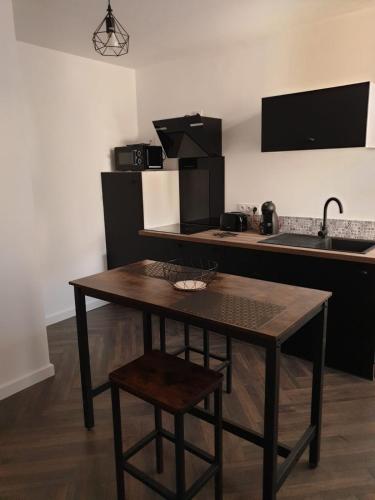a kitchen with a wooden table and a sink at Suite Miro Charme et volupté in Perpignan