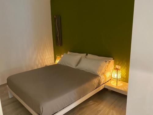 Cama en habitación con pared verde en Home3 beb appartments, en Bisceglie