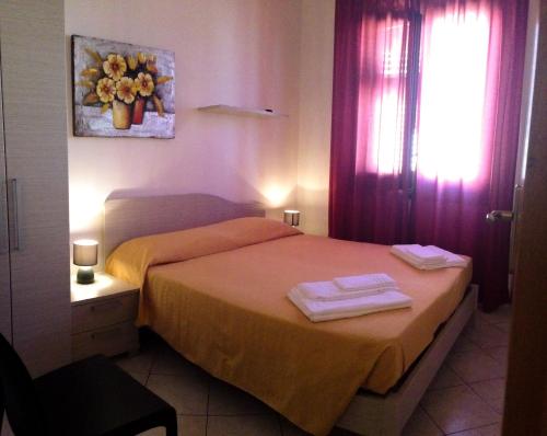 サン・ヴィート・ロ・カーポにあるBaglio del Mulino a Ventoのベッドルーム1室(ベッド1台、タオル2枚付)