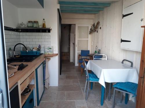une cuisine avec une table et des chaises dans une pièce dans l'établissement La Galerie, à La Chaume