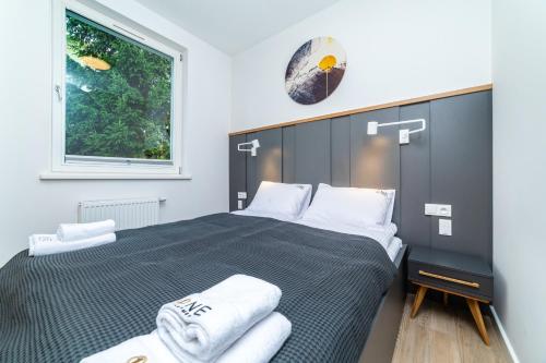 a bedroom with a large bed with towels on it at 5o5 Deluxe by OneApartments in Sopot