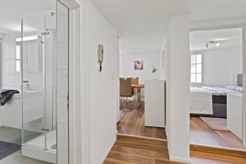 a white bathroom with a shower and a bedroom at GUEST HOUSE HERMES Contactless Self Checkin in Zürich