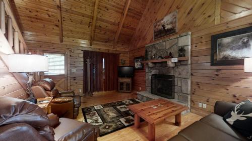 a living room with a fireplace in a log cabin at A Dream Come True cabin in Sevierville