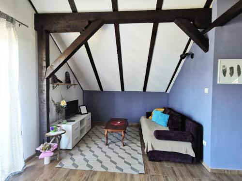 a living room with blue walls and a couch at Planinski kutak in Lovinac