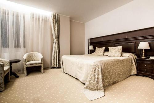 Un dormitorio con una cama grande y una silla. en Alpin Resort Hotel - Apartamentele 2403-2404- proprietate administrata de gazda privata, en Poiana Brasov