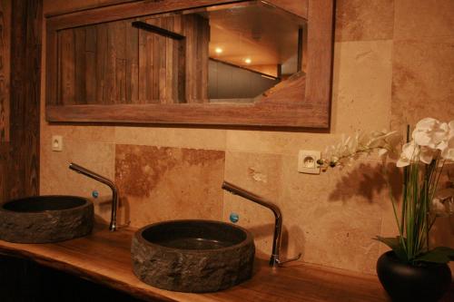 a bathroom with two sinks and a mirror and flowers at Domaine de Carnin in Beloeil