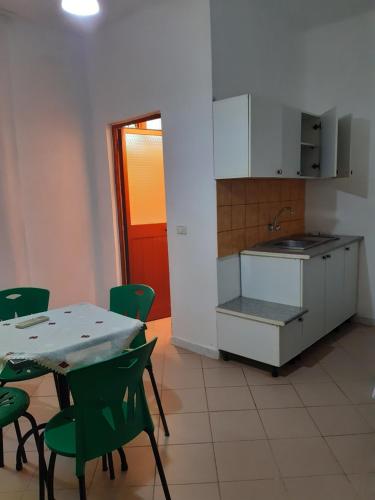 - une cuisine avec une table et des chaises vertes dans l'établissement H&A Guest House, à Golem