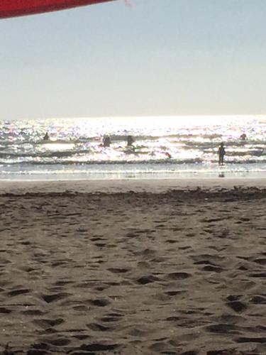 una playa con gente en el agua y el océano en Appartement à quelques mètres de plage, en Tánger