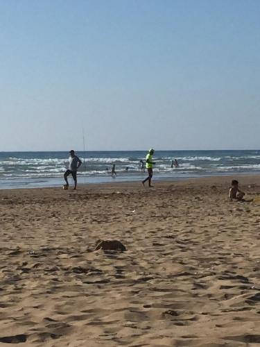 un grupo de personas jugando en la playa en Appartement à quelques mètres de plage, en Tánger