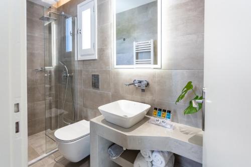 a bathroom with a sink and a toilet and a shower at Likio Studios in Batsi