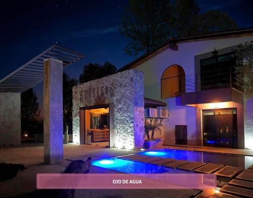 una casa con piscina por la noche en Bottega Hotel Boutique, en Valle de Guadalupe
