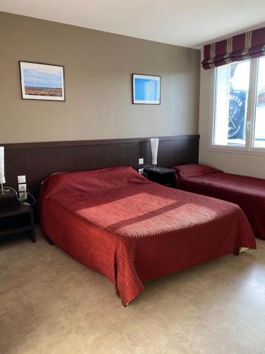 1 Schlafzimmer mit einem roten Bett und 2 Fenstern in der Unterkunft L'Escasse in Lit-et-Mixe