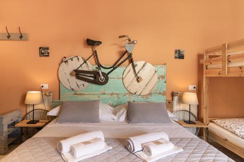 a bike hanging on a wall above a bed at Bed and Breakfast Bric & Brac in Grottammare