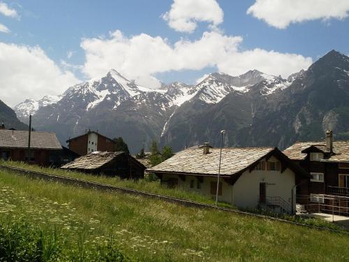 a village with a mountain range in the background at Schöne und Moderne Ferienwohnung in Grächen