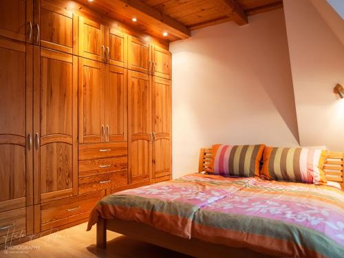 a bedroom with wooden cabinets and a bed at Moai Home Apartman Sárvár in Sárvár