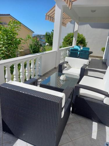 a balcony with wicker chairs and a glass table at Apartman Katica in Rab