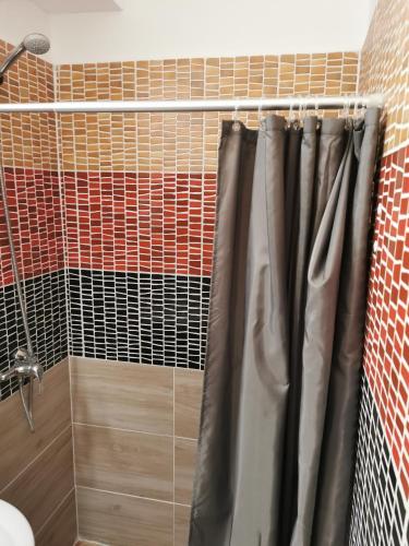a shower with a shower curtain in a bathroom at Thomas Panzió in Balatonfüred