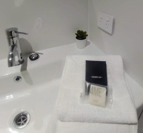 a book sitting on top of a bathroom sink at Bay House Motel in Bateau Bay
