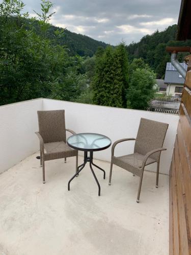 two chairs and a glass table on a balcony at Pension Formanka in Splzov