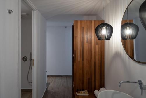 een badkamer met 2 verlichting en een spiegel bij ALLEGRO SUITES in Oia