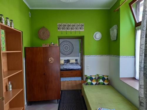 ein Zimmer mit grünen Wänden und einem kleinen Bett darin in der Unterkunft Gábor Vendégház in Eger