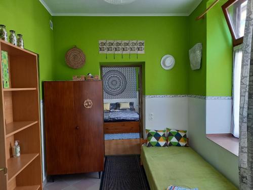 エゲルにあるGábor Vendégházの緑の壁の客室で、小さなベッドが備わります。