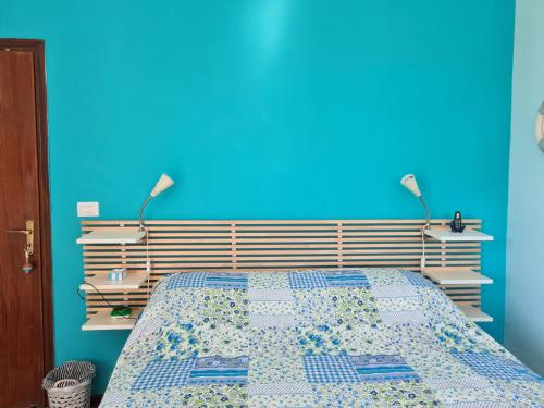 una camera con un letto con una parete blu di B&B Ondamarina a Lascari