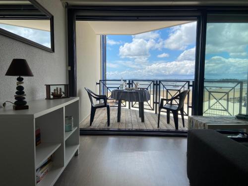 un salon avec une table et des chaises sur un balcon dans l'établissement T2 Vue exceptionnelle sur le bassin d'Arcachon, à Andernos-les-Bains