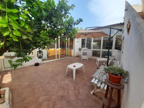 une terrasse avec une table blanche et un parasol dans l'établissement casadellestelle34, à Mazara del Vallo