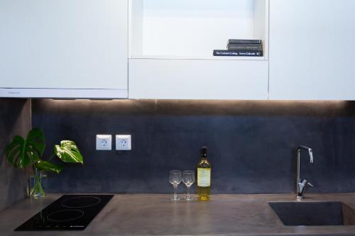 a bottle of wine sitting on a kitchen counter with two wine glasses at Likio Studios in Batsi