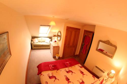 a small room with a bed and a couch at Red Stag Apartment in Nairn
