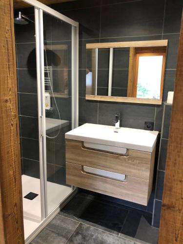 une salle de bain avec un lavabo blanc et un miroir dans l'établissement Le Pika, à Hauteluce