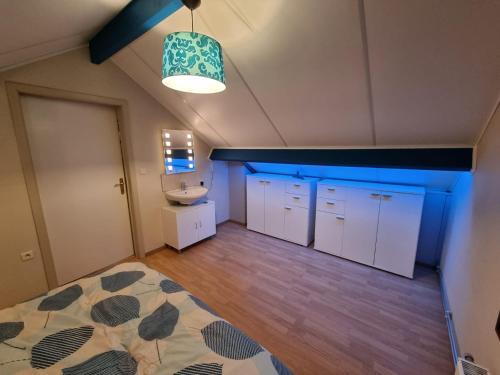 a room with a bathroom with a sink and cabinets at Au Vieux Lavoir in Alle