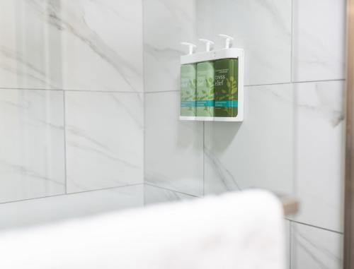 a bottle of green toothpaste is on the wall of a bathroom at Equus Inn I75 in Ocala