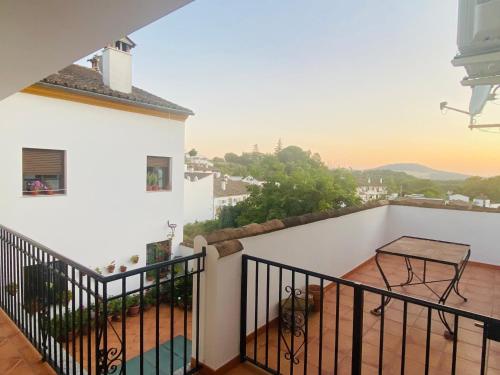a balcony of a white building with a table on it at Apartamento Rural La Bandolera in El Bosque