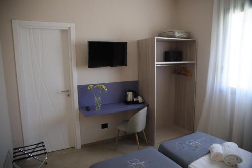 a small room with a desk and a tv on the wall at Valenti rooms & relax in Villaggio Mosè