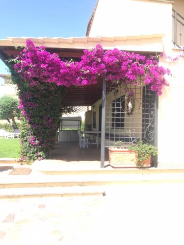 a pergola with purple flowers on a building at Appartamento VILLA ADRY in Rome