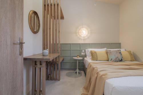 a bedroom with two beds and a table in it at Milk and Honey Residence in Zakynthos Town