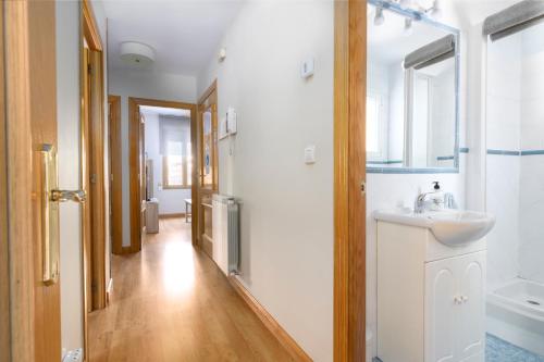 La salle de bains est pourvue d'un lavabo et d'un miroir. dans l'établissement Apartamento La Muralla - leonapartamentos, à León