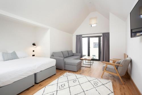 Habitación blanca con cama y sofá en Leggetts Lane en Whitstable