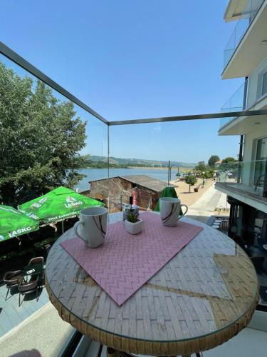 - une table sur un balcon avec vue sur l'eau dans l'établissement Lake View Tašić, à Veliko Gradište