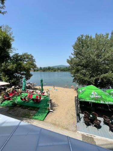a beach with a green boat and people on it at Lake View Tašić in Veliko Gradište