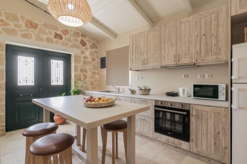Una cocina con una mesa con un bol de fruta encima. en Milk and Honey Residence, en Zakynthos