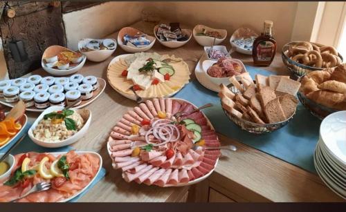 ein Tisch mit vielen Teller Essen drauf in der Unterkunft Hotel Le Filou in Hille