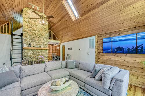 a living room with a couch and a stone wall at Patel's Cozy Cabin in Glenora