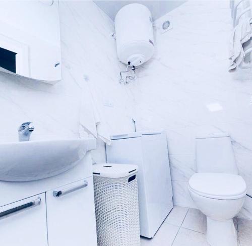 een witte badkamer met een toilet en een wastafel bij Apartments Orange in Kiev