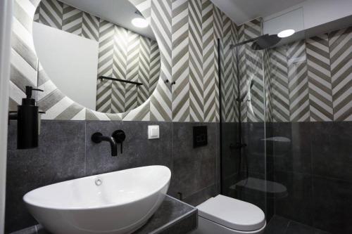 łazienka z umywalką, toaletą i lustrem w obiekcie Valory #1 Aesthetic Stay w Salonikach